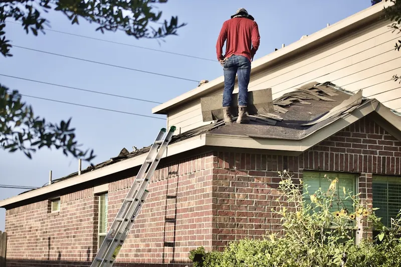 Professional roofer working on a residential roof in Villages of Montpelier
